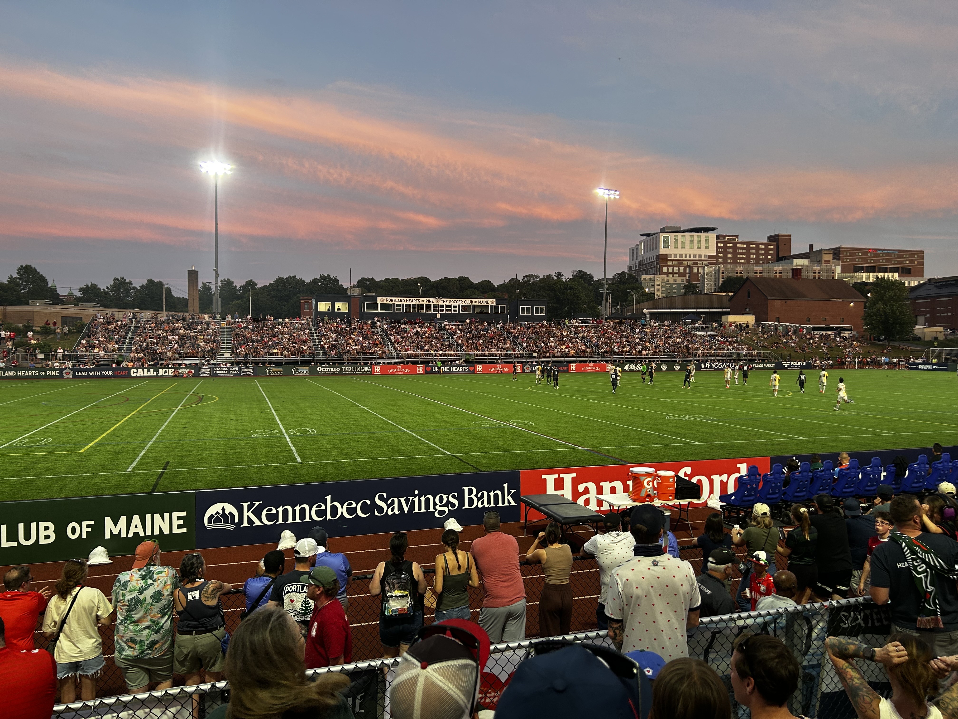Soccer players on the field at Fitzpatrick Stadium in Portland, Maine, with spectators in the stands.