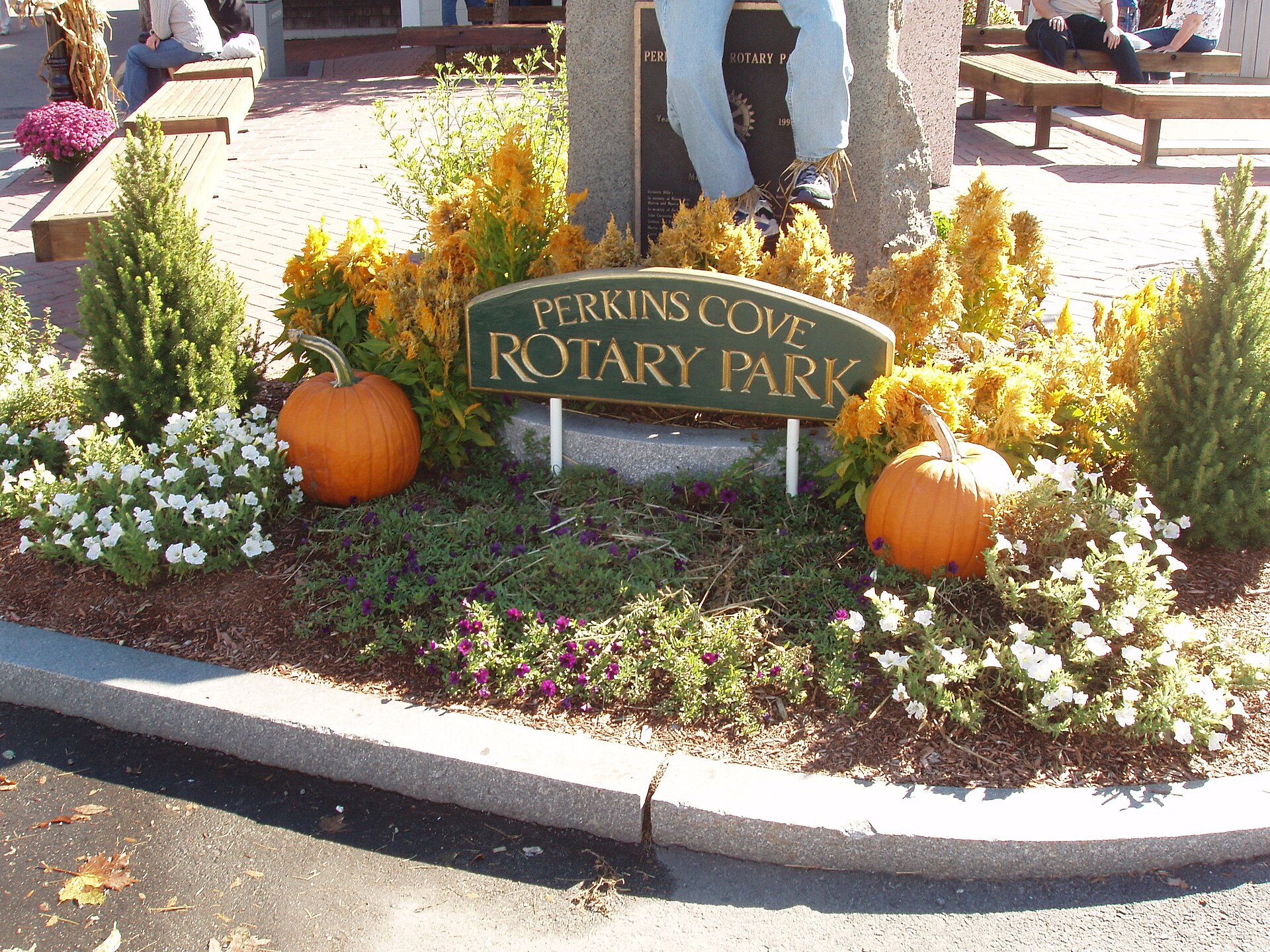 Pumpkins and fall flowers around the Perkins Cove Rotary Park sign during OgunquitFest.